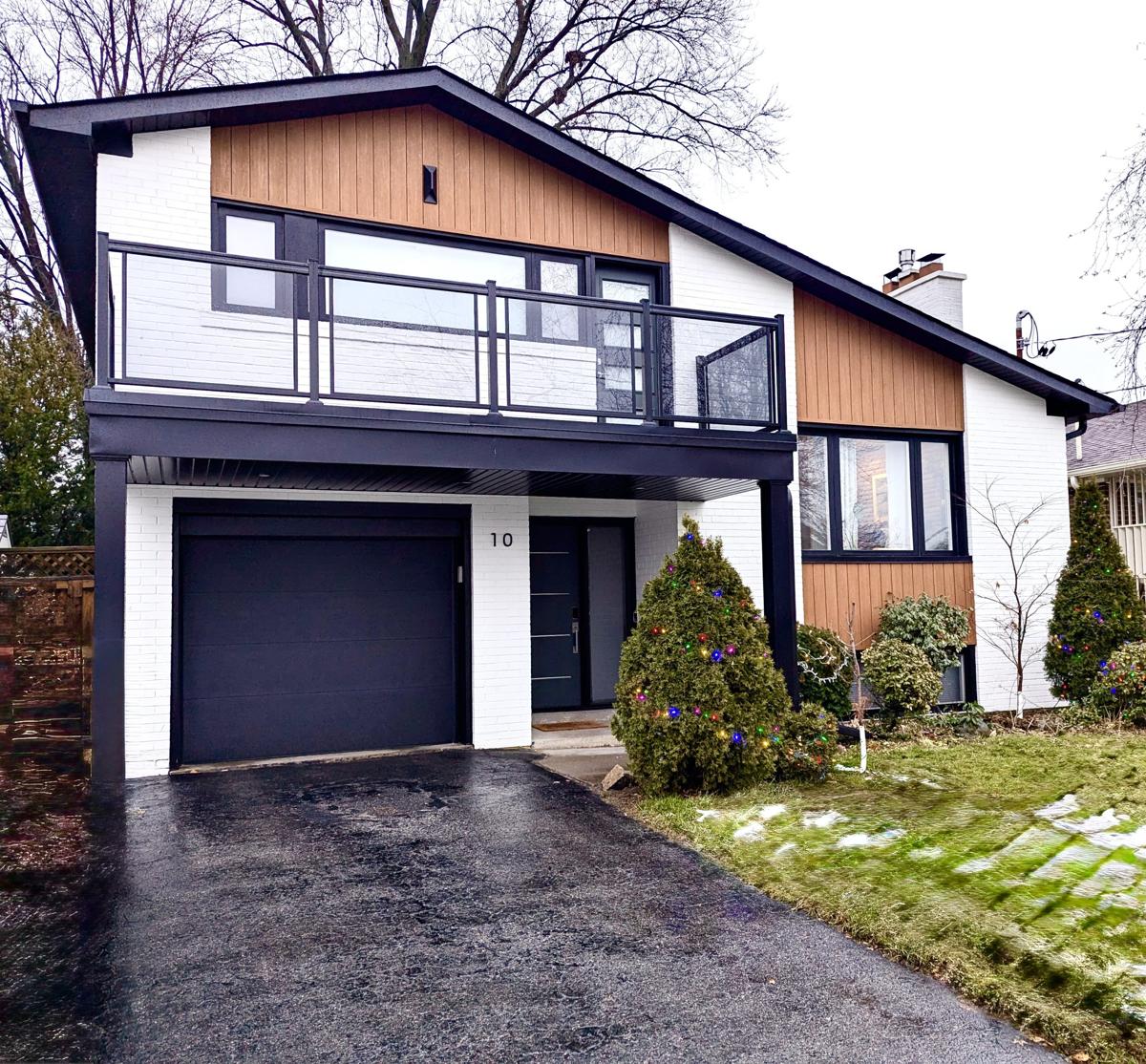exterior renovation of a modern home with white stone and wood panelling