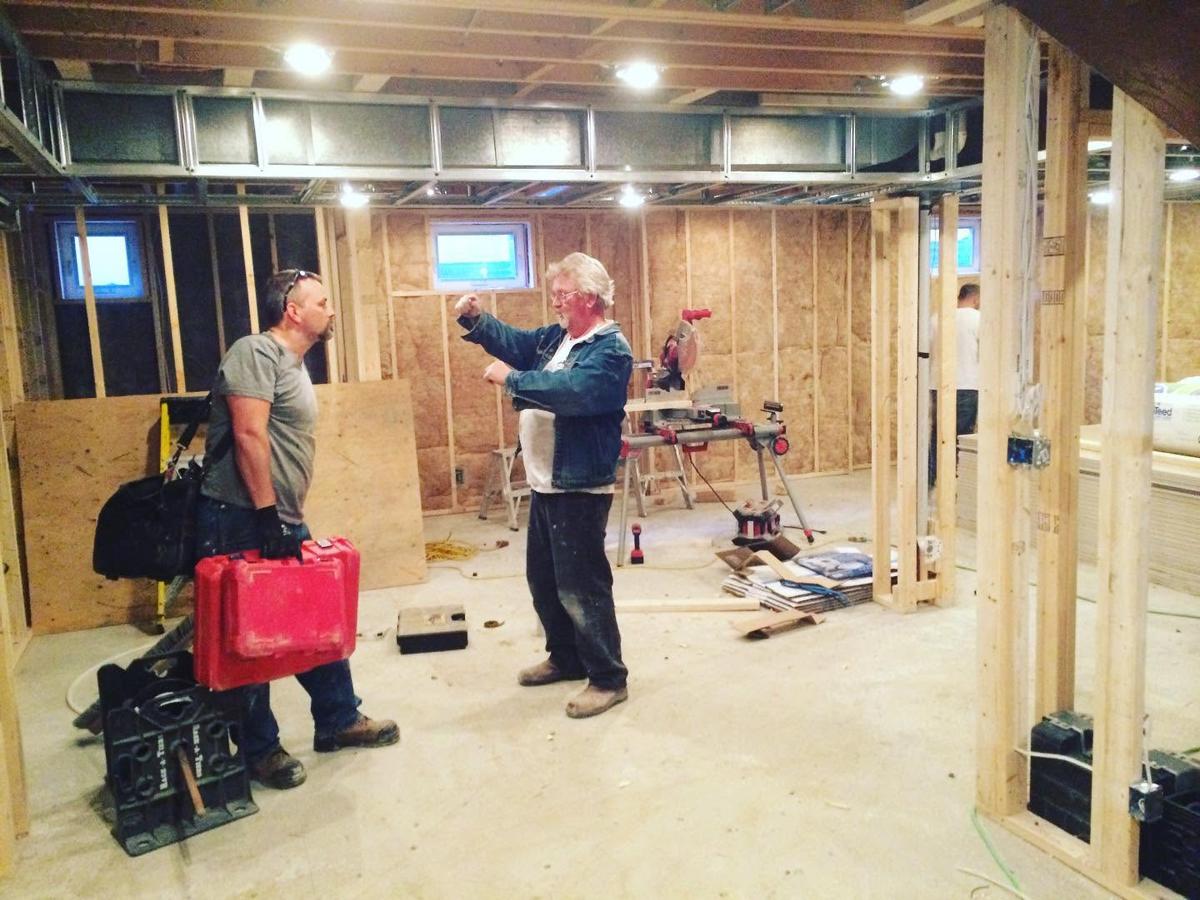 Basement renovation contractors communicating in an unfinished basement